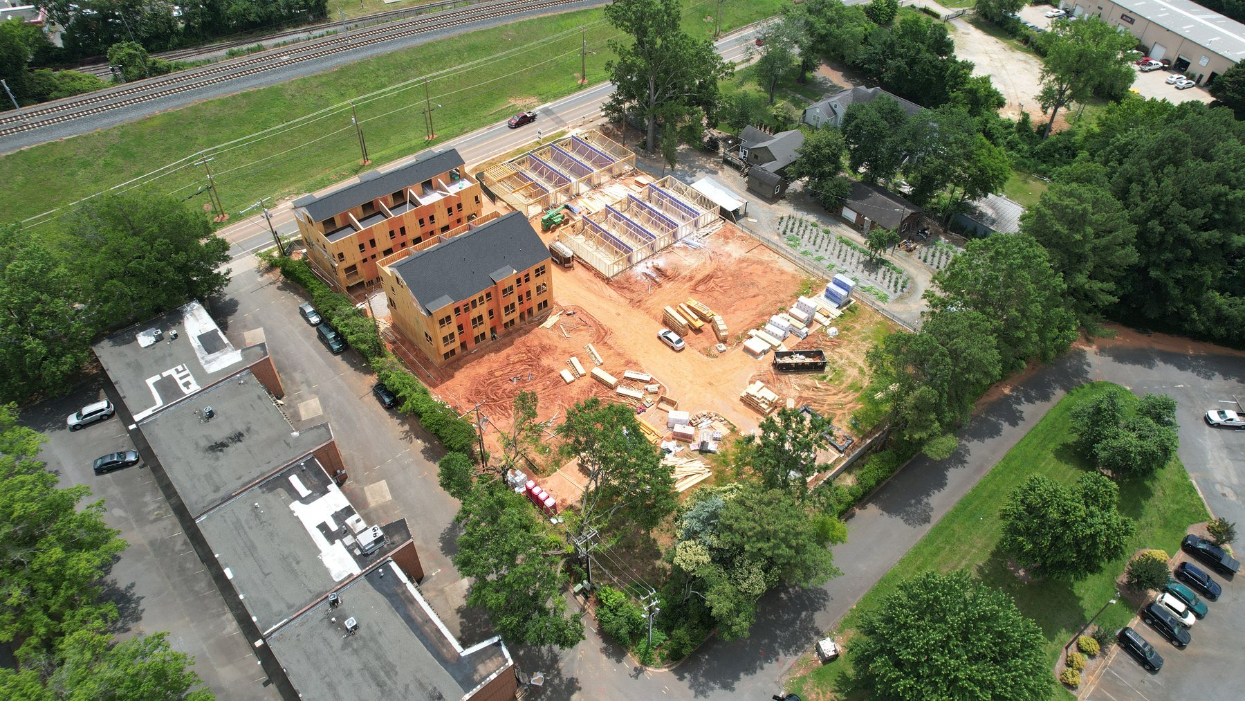 Aerial view of a townhome development under framing beside an active rail corridor