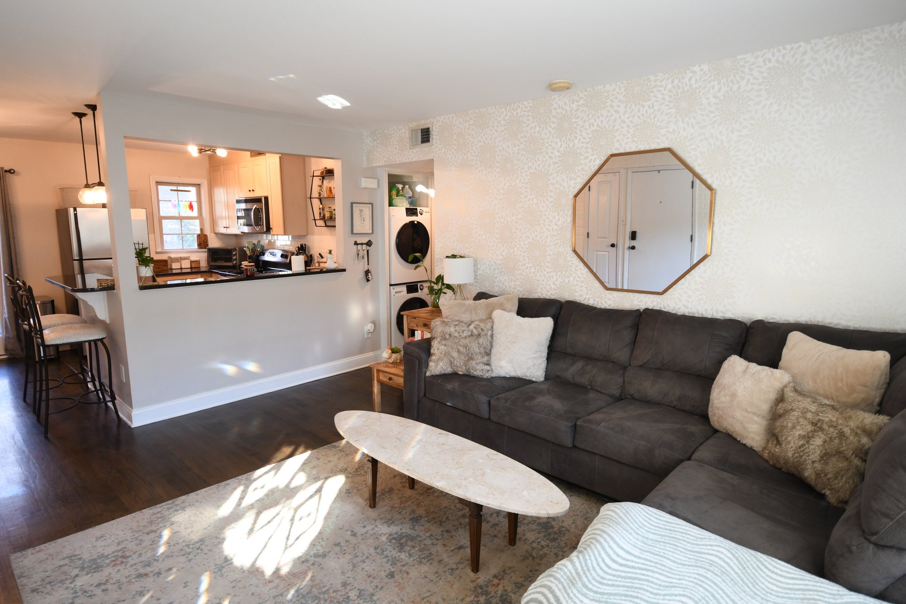 Sunlit living room with sectional sofa and pass-through to the kitchen
